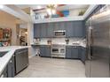 Modern kitchen features stainless steel appliances, gray cabinets, quartz countertops, and wood-look flooring at 484 Lanarkshire Pl, Apopka, FL 32712