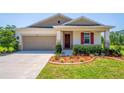 Inviting single-story home with a cozy front porch and manicured landscaping at 5064 Meadow Song Dr, Okahumpka, FL 34762