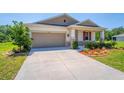 Well-maintained home featuring a two car garage and a charming front yard at 5064 Meadow Song Dr, Okahumpka, FL 34762