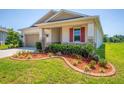 Single-story home showcasing a beautifully landscaped front yard with stone accents at 5064 Meadow Song Dr, Okahumpka, FL 34762