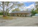 Charming single-story home featuring a covered front porch with outdoor seating at 5410 Deleon Springs Ranch Rd, De Leon Springs, FL 32130