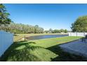 Scenic backyard view featuring a pond, expansive green lawn, and partial fence line enhancing privacy at 5479 Saint Regis Way, Port Orange, FL 32128