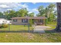 Cozy single-Gathering home boasts a fenced yard with mature trees at 816 W Franklin Ave, Deland, FL 32720