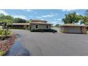 Exterior showcasing the home, detached garage, spacious driveway and well-kept landscaping at 910 N Kepler Rd, Deland, FL 32724