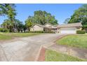 A cozy one-story home with an attached garage and well-maintained front yard on a sunny day at 101 Sweetwater Oaks Ln, Daytona Beach, FL 32114
