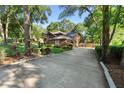Long driveway leading to a brick home surrounded by lush greenery at 1081 Torchwood Dr, Deland, FL 32724