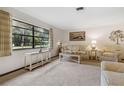 Bright living room featuring a large window and plush neutral carpet at 1128 Heidi Ct, Deland, FL 32720