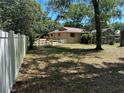The expansive backyard features a beautiful lawn with a new white fence and screened-in patio at 1179 Heidi Ct, Deland, FL 32720