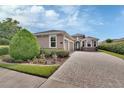 Charming single-story home featuring a three-car garage, paved driveway, manicured landscaping, and stone accents at 1188 Eggleston Dr, Deland, FL 32724