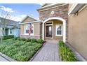 Inviting front entrance with a brick paved walkway, colorful landscaping, and a classic American flag at 1219 Victoria Hills N Dr, Deland, FL 32724