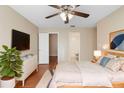 Cozy main bedroom with hardwood floors, ceiling fan, and view into ensuite bathroom at 1222 Madelena Ave, Winter Springs, FL 32708