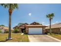 Charming single-story home featuring a two-car garage, brown-colored trim, and a well-maintained front yard at 133 Wood Ibis Ct, Daytona Beach, FL 32119