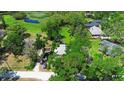Aerial view showcasing the property with mature trees, surrounding greenery and a pond in the background at 150 Lake Charles Rd, Deland, FL 32724