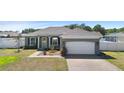 Charming single-story home with a brick-paved driveway, well-manicured lawn, and inviting front porch at 1613 Lady Fern Trl, Deland, FL 32720