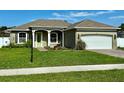 Charming single-story home with manicured lawn, a two-car garage, and a bright green front door at 1613 Lady Fern Trl, Deland, FL 32720