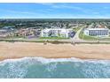 Aerial view of a sandy beach and the ocean alongside a condo complex at 1926 Ocean Shore Blvd # 3050, Ormond Beach, FL 32176