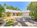 Attractive single-story home with a well-maintained lawn, a metal roof, and a two-car garage at 1927 Orange Tree Dr, Edgewater, FL 32141