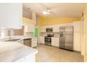 Bright kitchen with white cabinets, stainless steel appliances, marble counters, and ample counter space at 1927 Orange Tree Dr, Edgewater, FL 32141