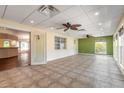 Large living room featuring neutral-toned walls, tile floors, ceiling fans, and abundant natural light at 1927 Orange Tree Dr, Edgewater, FL 32141