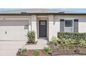 Inviting entryway with a dark front door, manicured landscaping, and modern accents at 223 Courtland Blvd, Deltona, FL 32738