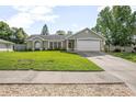 Charming one story home featuring a manicured lawn, neutral paint, and an attached two-car garage at 227 Heronwood Cir, Deltona, FL 32725