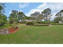 Expansive front yard with mature trees and meticulous landscaping surrounds this suburban home at 2427 Beck Cir, Deltona, FL 32738