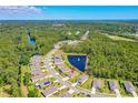 An aerial view shows the neighborhood's proximity to lush green spaces and the community pond with a fountain at 2901 Monaghan Dr, Ormond Beach, FL 32174