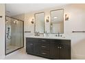 Modern bathroom with a double vanity, black fixtures, and glass-enclosed shower at 3333 Atmore Ter, Ocoee, FL 34761