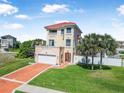 Inviting home with a red tile roof, two balconies, manicured lawn, and a driveway leading to an attached garage at 3817 Islamorada Dr, Ormond Beach, FL 32176