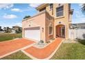Close up of charming home featuring a red brick driveway, attached garage, and welcoming front entrance at 3817 Islamorada Dr, Ormond Beach, FL 32176