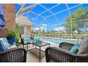 Screened-in outdoor living space with comfortable seating and a view of the refreshing in-ground swimming pool at 4 Huntsman Look, Ormond Beach, FL 32174
