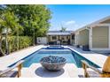 Outdoor pool featuring a fire pit, seating area, and lush landscaping in the backyard at 426 N Boyd St, Winter Garden, FL 34787