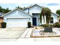 Attractive single-story home featuring a two-car garage, a blue front door, and modern landscaping at 4339 Northern Dancer Way, Orlando, FL 32826
