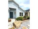 Inviting front entrance with a dark blue door, decorative accents, and stone landscaping at 4339 Northern Dancer Way, Orlando, FL 32826