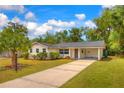Single-story home featuring manicured landscaping, a new roof, and a covered carport at 508 W Hogle Ave, Deland, FL 32720