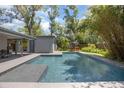 Backyard pool with a modern design, surrounded by lush landscaping and patio at 510 E Wisconsin Ave, Orange City, FL 32763