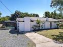Exterior of home featuring white siding, a gravel drive, and an enclosed screened in pool at 5400 Turton Ln, Port Orange, FL 32127