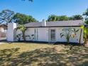 Front of home, highlighting a white exterior, well-kept lawn, and neat landscaping at 5400 Turton Ln, Port Orange, FL 32127