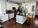 Spacious kitchen with white cabinetry, black countertops, stainless steel appliances, and a convenient island at 606 W Voorhis Ave, Deland, FL 32720