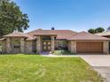 Charming brick home featuring a well-manicured lawn, mature trees, and a double-door entrance, creating a welcoming curb appeal at 685 Enterprise Osteen Rd, Osteen, FL 32764