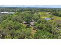 Aerial view of home nestled among lush green trees, ponds, and open fields at 800 Hidden Oaks Ln, Oak Hill, FL 32759