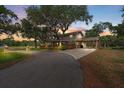 Charming home with a porte cochere and lush landscaping, nestled under mature trees at 800 Hidden Oaks Ln, Oak Hill, FL 32759