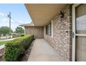 Inviting brick entryway featuring a covered porch and a well-manicured hedge providing privacy at 808 Jutland St, Deltona, FL 32725