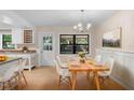 Bright dining area featuring a wood table with white chairs and modern chandelier at 825 Baltimore Dr, Orlando, FL 32810