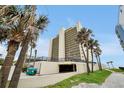 A condominium tower surrounded by mature palm trees, providing a resort-like ambiance at 89 S Atlantic Ave # 505, Ormond Beach, FL 32176