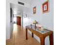 Well-lit hallway with tiled floors, stylish table, and wall art creates a welcoming atmosphere at 89 S Atlantic Ave # 505, Ormond Beach, FL 32176