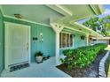 Welcoming front porch featuring a vibrant green wall, potted plants, and charming decor at 1 Cobblestone Trl, Ormond Beach, FL 32174