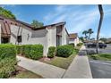 A sidewalk view of a lovely condo unit with manicured bushes and designated parking at 101 Grand Plaza Dr # A30, Orange City, FL 32763