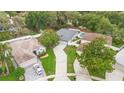 Aerial view of a home with a driveway and a pool, situated among mature trees and fenced backyard at 105 Golfside Cir, Sanford, FL 32773