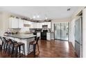 Open kitchen boasts white cabinets, black appliances, breakfast bar, and wood floors at 1135 5Th St, Orange City, FL 32763